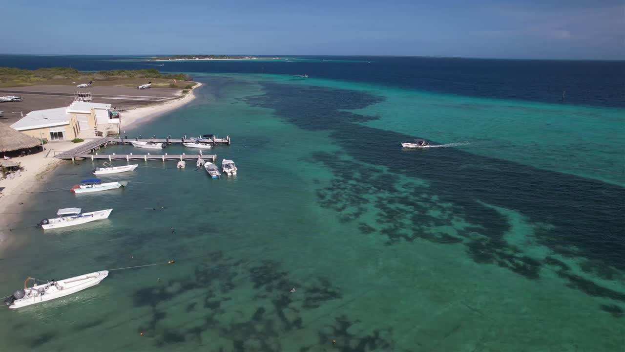 Aerial zoom out bird fly, Wooden Pier on Caribbean Coast island, small town Gran Roque