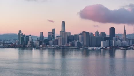 aerial pull back of san francisco skyline and bay bridge at dawn