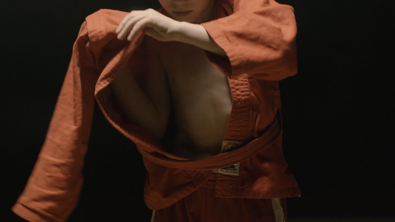 niño en uniforme de sambo naranja cinturón de atado