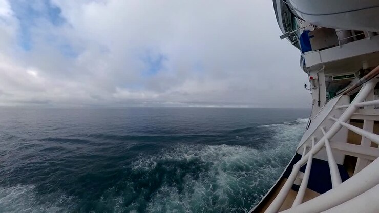 Vista laterale di una nave da crociera in mare - carrellata indietro attraverso il corrimano.