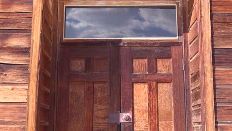 Reflection-in-old-glass-windows-reveals-the-sky-above-the-abandoned-ghost-town-of-Bodie-California