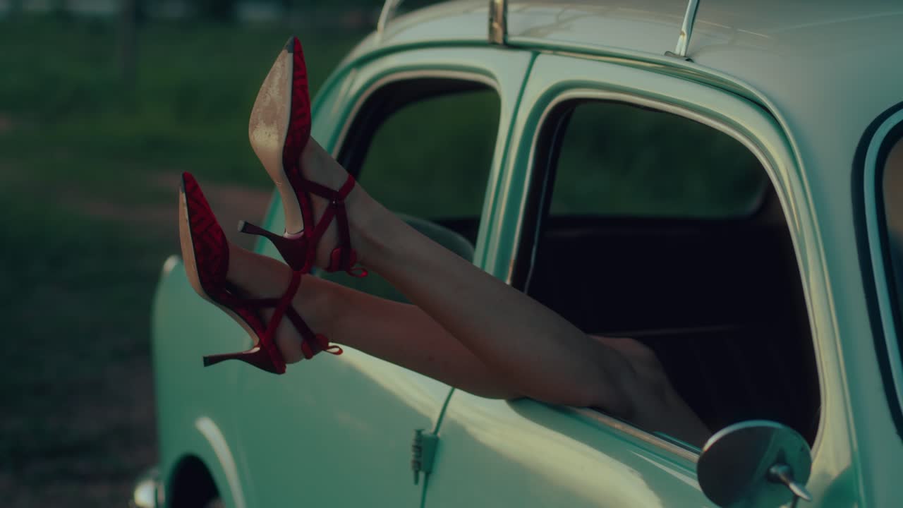 Woman's legs sticking out of a vintage car window