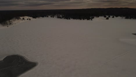 Panorámica-Sobre-Un-Lago-Congelado-Cubierto-De-Hielo-Y-Nieve