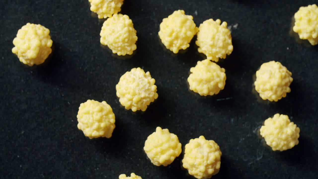 Top shot of yellow cells laying on a black surface. Surface spinning clockwise