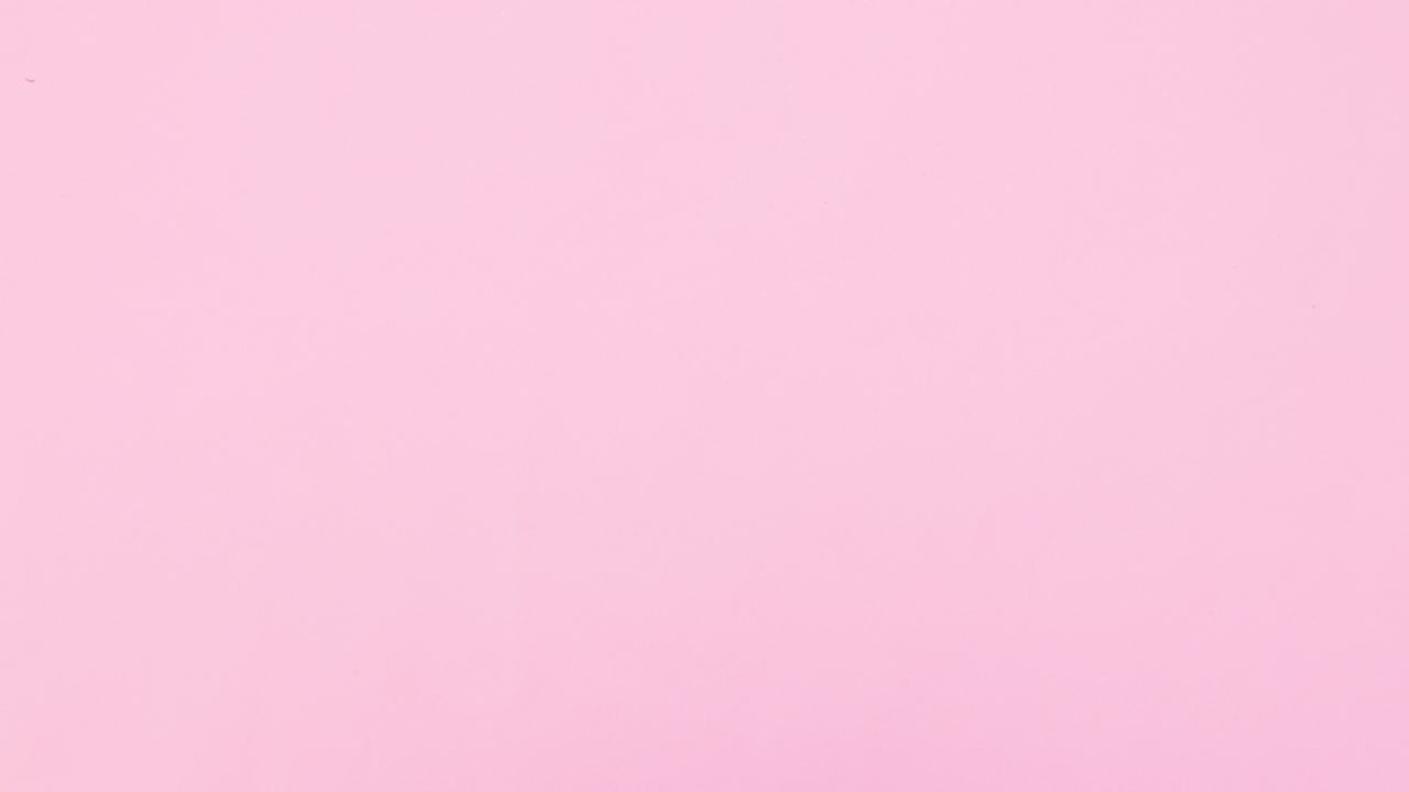 Christmas pine branches with red ornaments and gold stars on right side of pastel pink theme. Stop motion