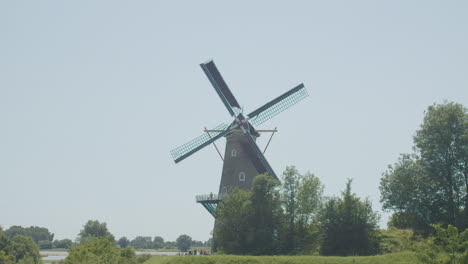 wide shot of classical dutch windmill with spinning sails