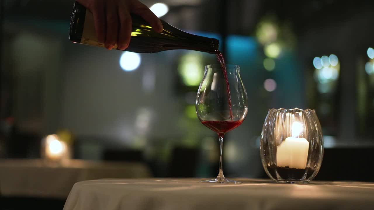 Red wine pouring, slow motion with lots of bokeh while dinner in Italy.