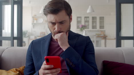 Upset business man reading bad news on phone at home office