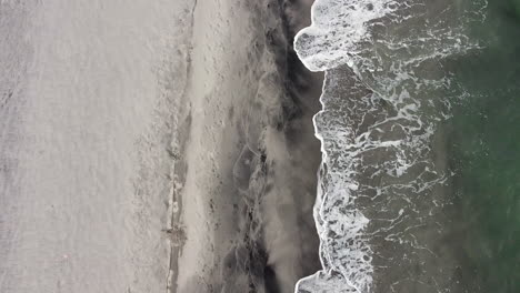 aerial drone footage of waves at the beach during daytime