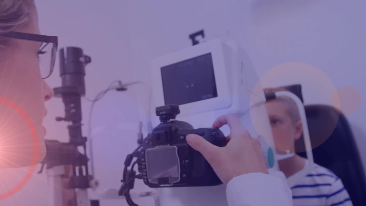 Animation of light spots and trails over diverse doctor and patient using slit lamp