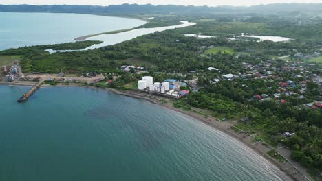 panoramic aerial drone shot of fuel storage facility along the coast of a quaint, lush, tropical island during daytime. virac, catanduanes.