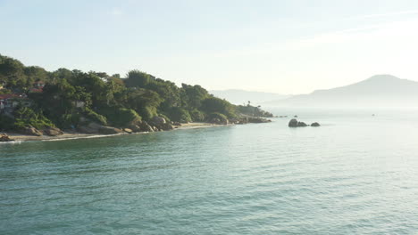 aerial cinematic view rainforest coastline sunset and mist, jurere internacional, florianopolis, santa catarina, brazil