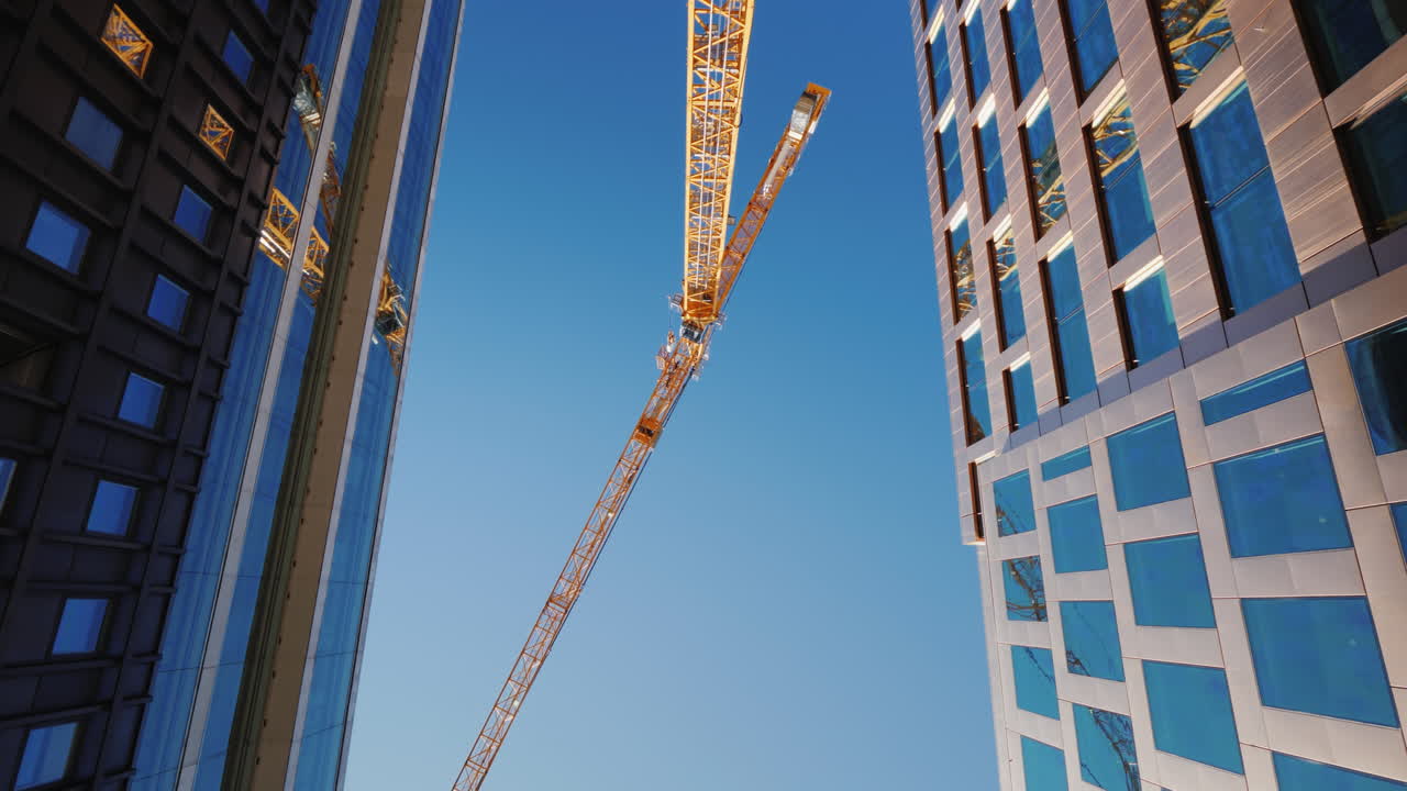 A Vertiginously High Tower Crane In The Downtown Of The Modern City Rotating Video