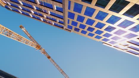 a vertiginously high tower crane in the downtown of the modern city rotating video