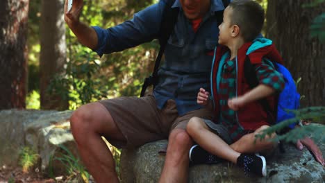 padre e hijo tomando un selfie en el teléfono móvil en el parque