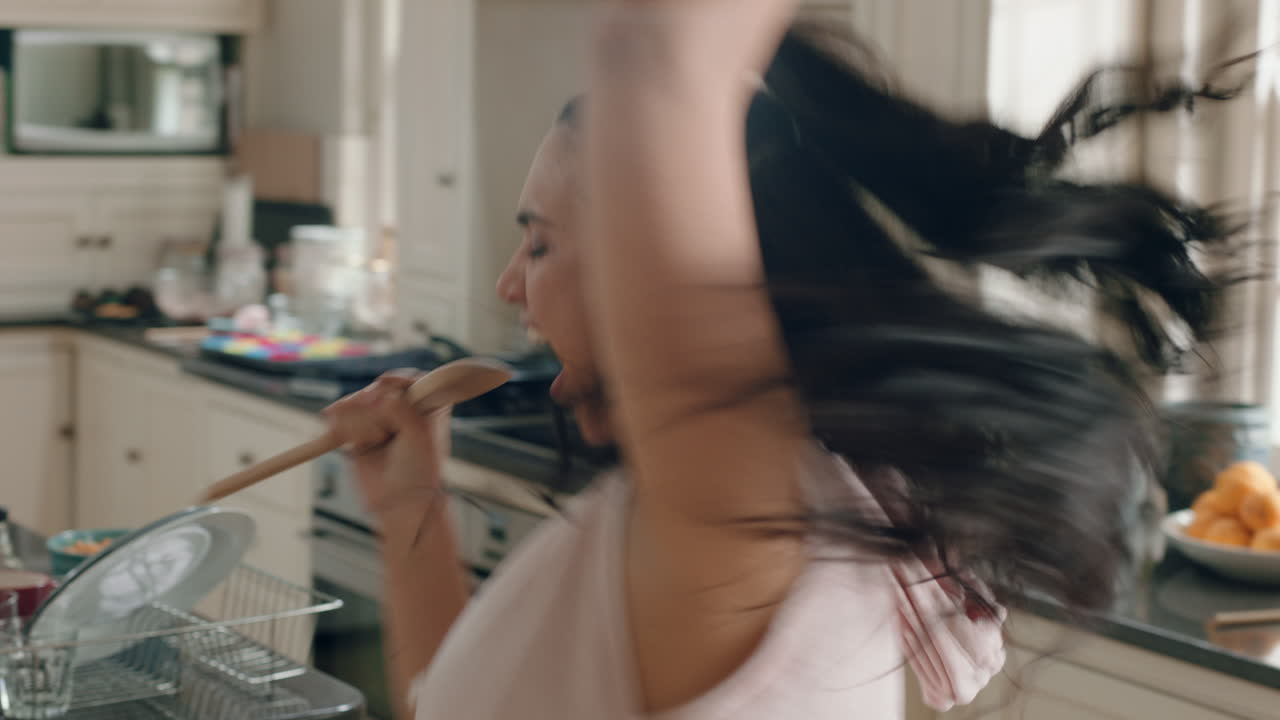 chica adolescente con sobrepeso feliz bailando en la cocina divirtiéndose celebrando el fin de semana realizando movimientos de baile divertidos en casa disfrutando de la celebración del fin de semana
