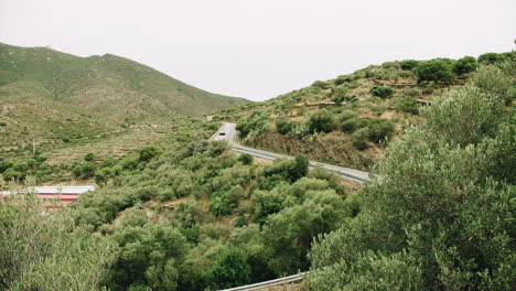cars driving down swirvy road in a mountain landscape