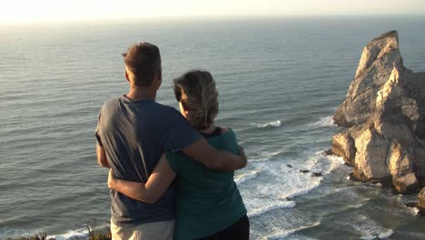 married couple of hikers standing at cliff