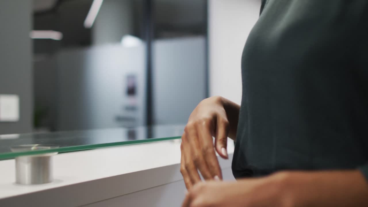 la mujer de negocios tiene la temperatura comprobada por un hombre de raza mixta que usa máscara facial en la recepción de la oficina