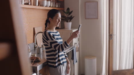 Junge-Asiatische-Frau-Führt-Einen-Video-Chat,-Der-Ihr-Smartphone-In-Gebärdensprache-Hält-Und-Zu-Hause-Mit-Einem-Gehörlosen-Freund-Auf-Dem-Mobiltelefon-Chattet