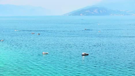 Lanchas-A-Motor-Flotando-En-Un-Tranquilo-Lago-De-Garda,-Italia