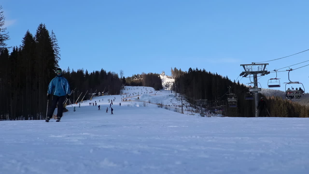 Bukovel, Ukraine - January 20, 2020: People skiing near a ski lift at a resort