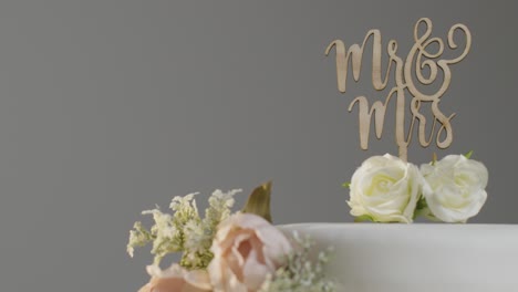 close up of wedding cake against grey studio background at wedding reception 2