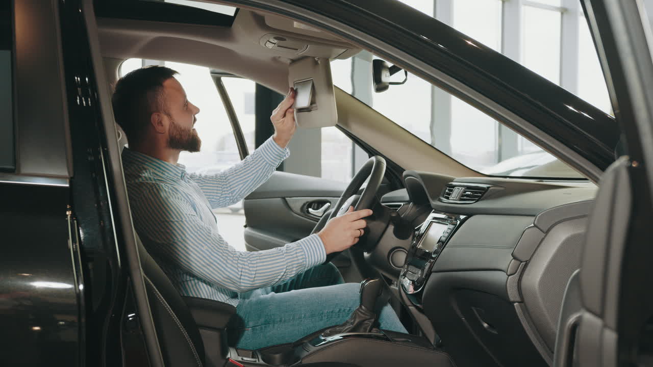 Uomo che esamina gli interni dell'auto in concessionaria