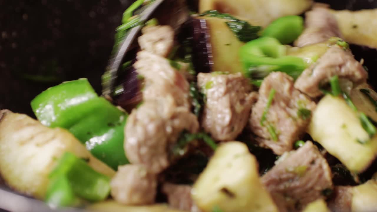 Chicken or pork stew with red and green pepper onion, and spices cooking in a frying pan. Traditional mexican cuisine, tacos preparation, ragout.