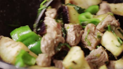 chicken or pork stew with red and green pepper onion, and spices cooking in a frying pan. traditional mexican cuisine, tacos preparation, ragout.