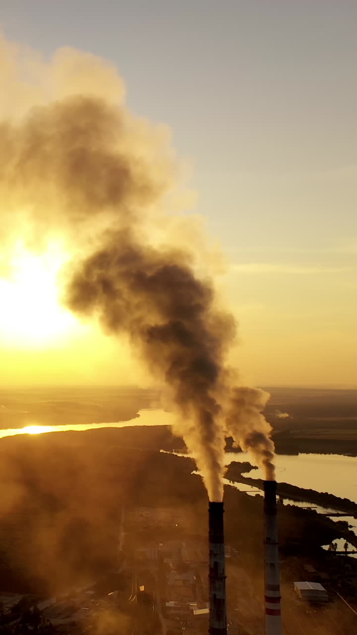 Thick smoke of factory chimneys. Smoke and steam from high chimney of power plant Vertical video