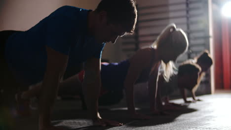 four people doing press ups at a gym