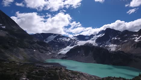 beautiful view of a turquoise lake surrounded by the rocky mountains during summer. Wide drone shot