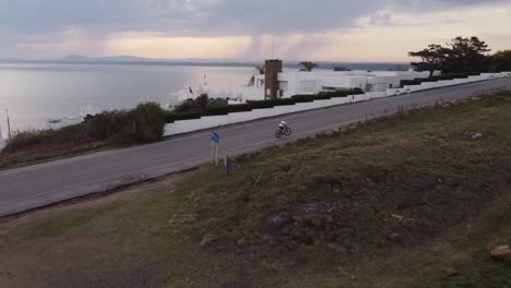 bicycle cyclist reaching the top of slope front to ocean