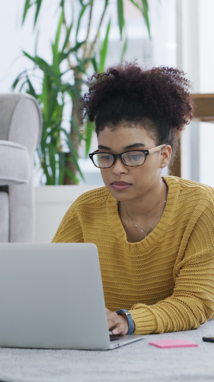 Young Woman with Glasses Typing on Laptop at Home