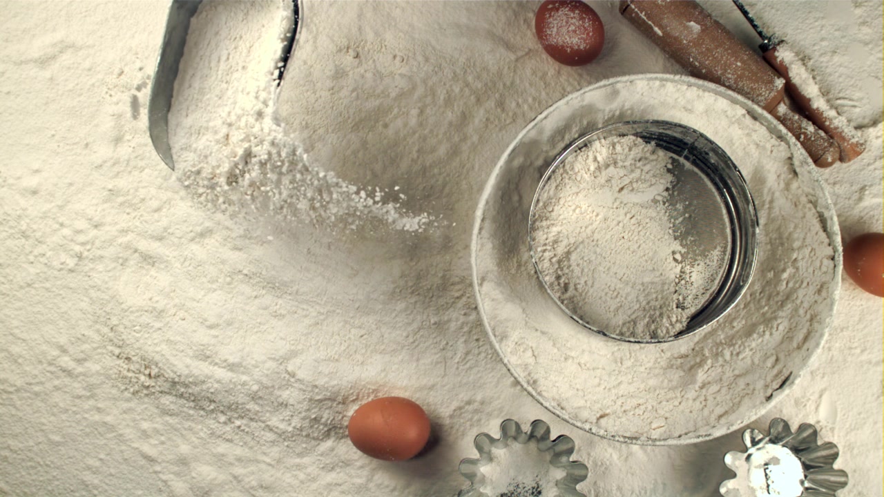 Sakte film av mel som øses og siktes til baking
