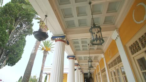 Point-view-lantern-hanging-on-ceiling-columns-building-with-palm-trees