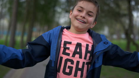 un adolescente sonriente mirando a la cámara en el parque. un adolescente feliz divirtiéndose al aire libre.