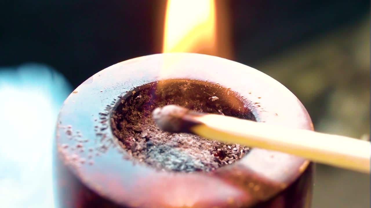 tubo de madera extremo de cerca vista superior quema tabaco con partido estilo de fumar a la vieja moda produciendo humo azul en interiores fuego haciendo daño visible al dispositivo de fumar en interiores advertencia de salud
