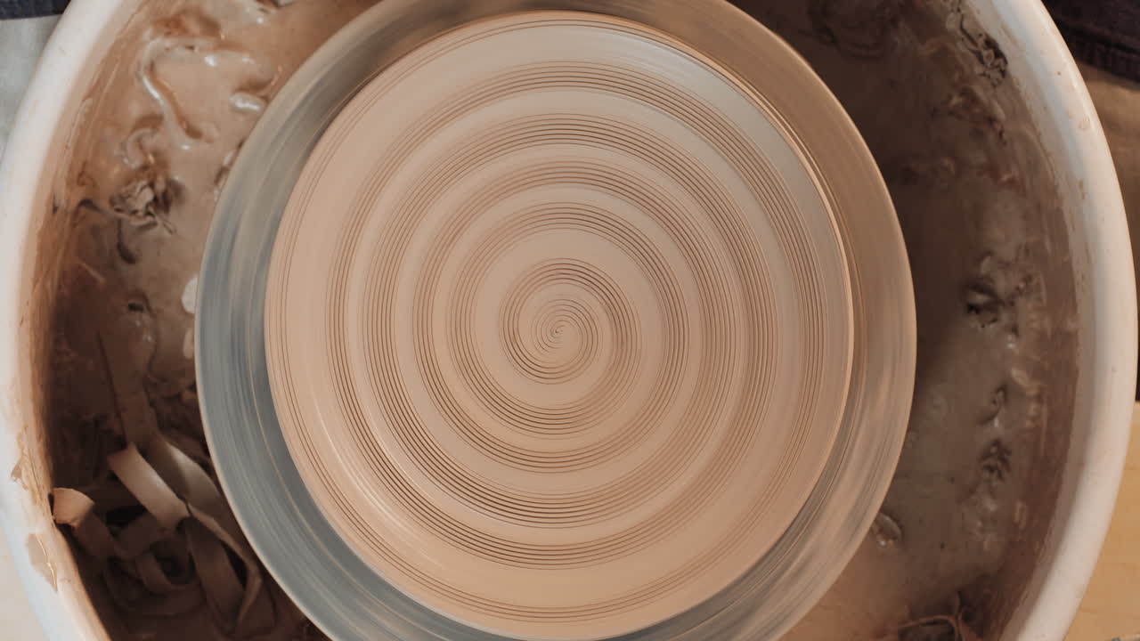 manos moldeando arcilla en una rueda de cerámica