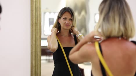 woman admiring necklace in a mirror at a store