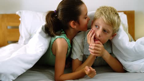 Siblings-interacting-with-each-other-on-bed-in-bedroom