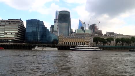 hand-held shot of the walkie talkie building and financial district from the thames river, london