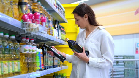 mujer comprando aceite de cocina en una tienda de comestibles