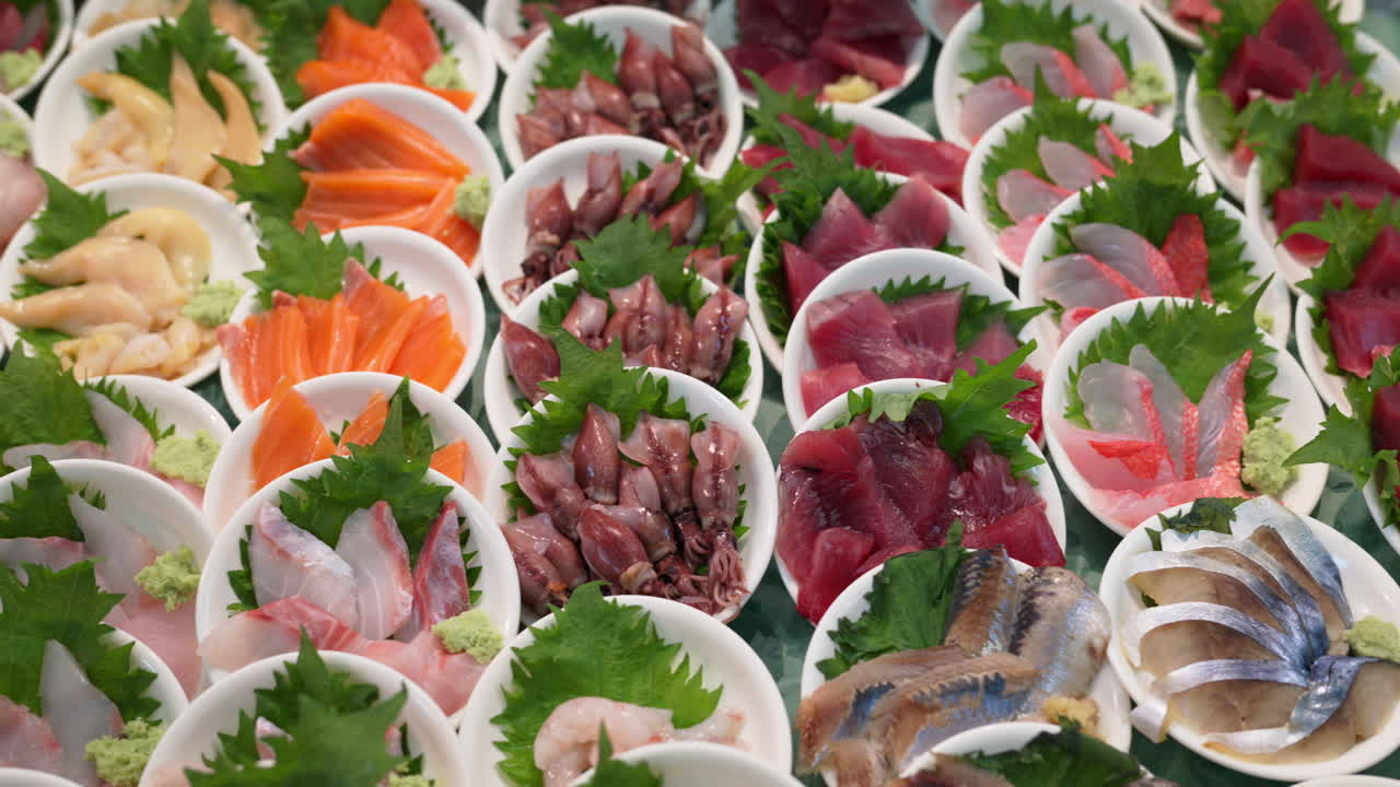 Close up of different seafood in small white bowls on display at the Tsukiji Fish Market in Japan