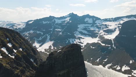 Luftaufnahmen-Von-Drohnen-Mit-Menschen,-Die-Sich-Nach-Einer-Wanderung-Auf-Dem-Gipfel-Des-Innerdalstårnet-Ausruhen-Und-Das-Wunderbare-Panorama-Des-Innerdal-Tals-In-Norwegen-Bewundern