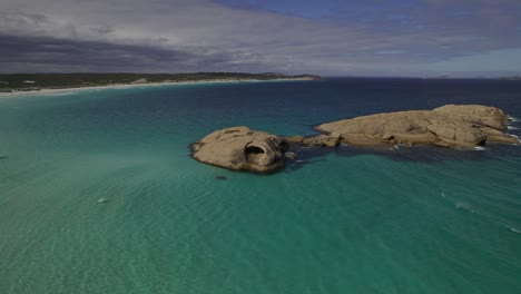 imágenes de drones de agua turquesa y rocas de hobos en la playa del crepúsculo en esperance
