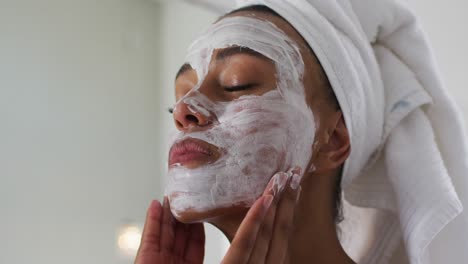 Mujer-Afroamericana-Aplicando-Mascarilla-En-El-Baño-De-Casa