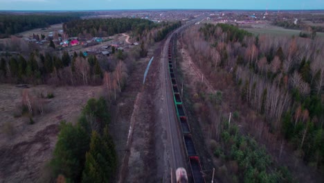 a freight trains travel towards the village.