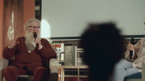 periodista entrevistando a un autor sénior en un evento de lanzamiento de libros